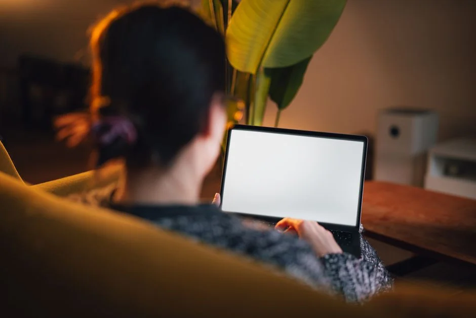 Un bureau lumineux avec un livre de design, un ordinateur portable et des outils créatifs, parfait pour stimuler l’inspiration.